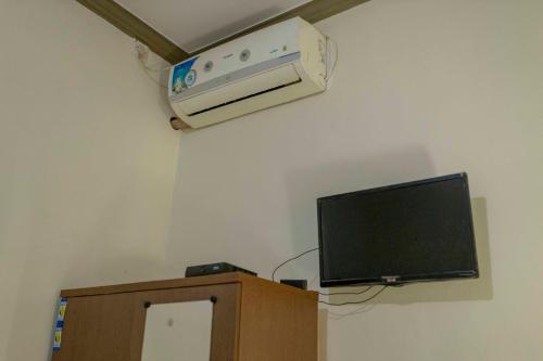 a room with a television and a air conditioner on the wall at Sandik Local Stay in Midang