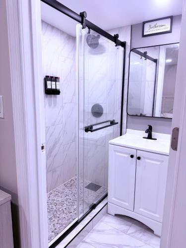 a white bathroom with a shower and a sink at New Private Studio JFK in Morris Park
