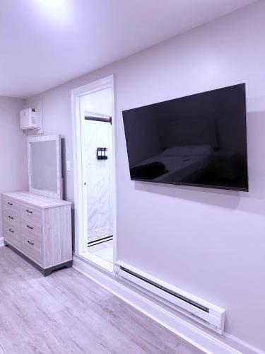 a living room with a large flat screen tv on the wall at New Private Studio JFK in Morris Park