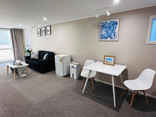 a living room with a white table and a couch at Large 1BR Suite and Private Lounge in Tauranga