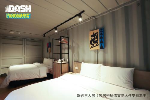 a bedroom with two beds and a sign on the wall at Dash Forwaves Hotel in Toucheng