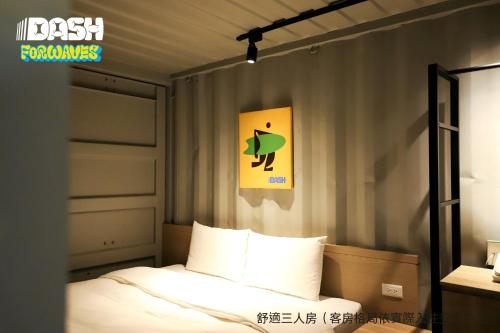 a bedroom with a bed and a sign on the wall at Dash Forwaves Hotel in Toucheng