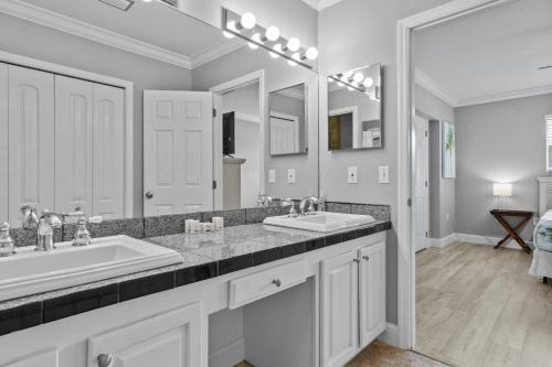 a bathroom with two sinks and a large mirror at Paradise PalmsDockPoolKayaks GrillView! in Marathon