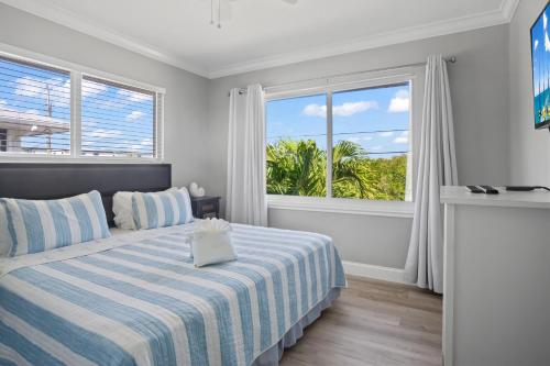 a bedroom with a bed and a large window at Paradise PalmsDockPoolKayaks GrillView! in Marathon