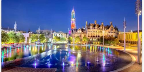 a large fountain in the middle of a city at night at 2 Spacious Double Bedroom Apartment - Bradford in Bradford
