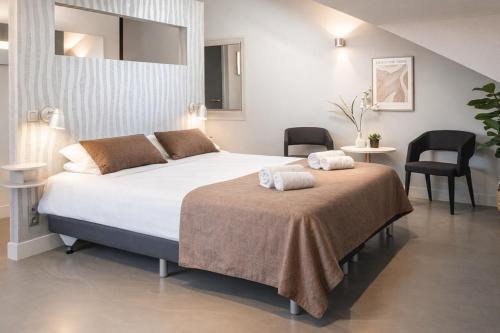 a bedroom with a large bed and two chairs at Luxe Suite, Near Station & Free WiFi in Oss