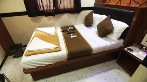 a bed with white sheets and pillows at FabHotel Star Hill in Mumbai