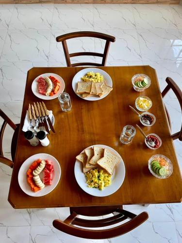 a wooden table with plates of food on it at Villa Avora Ridge in Kandy