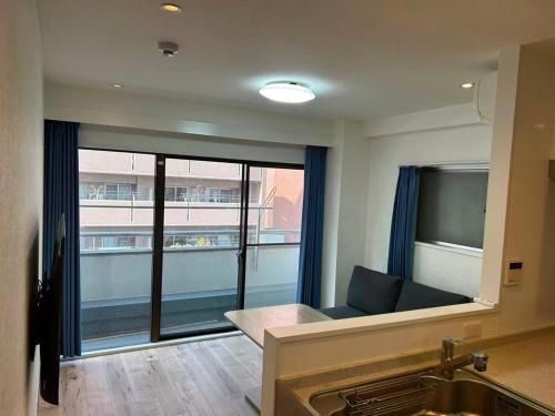 a living room with a couch and a large window at Eko House in 横浜石川町駅 601室 in Yokohama
