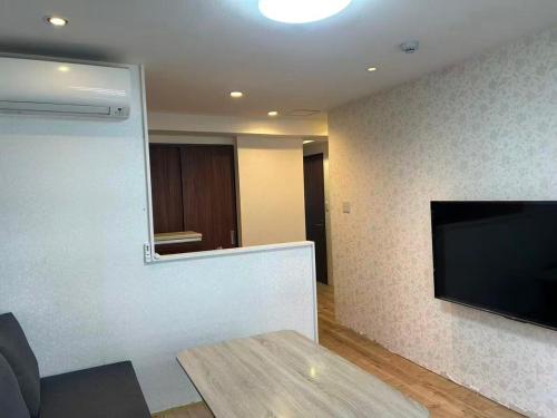 a living room with a large flat screen tv at Eko House in 横浜石川町駅 601室 in Yokohama