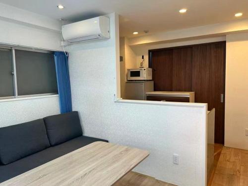 a living room with a couch and a kitchen at Eko House in 横浜石川町駅 601室 in Yokohama