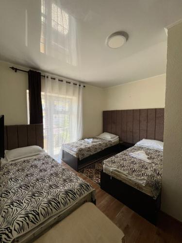 a bedroom with two beds and a window at Inn Kochevnik in Cholpon-Ata