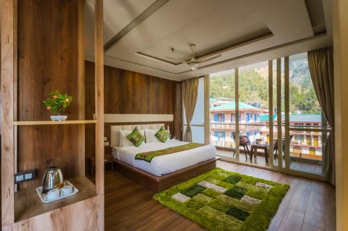 a bedroom with a bed and a large window at Tripli Hotels Shivaay in Dharamshala