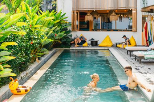 a man and a woman swimming in a swimming pool at Sokkool Coliving and Coworking - Near Berawa Beach in Canggu