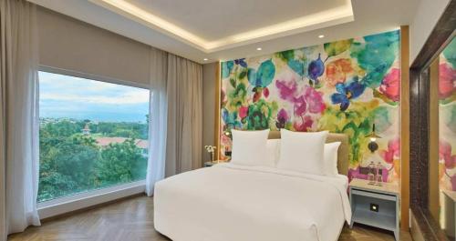 a bedroom with a white bed and a large window at Hotel Royal Orchid Bangalore in Bangalore
