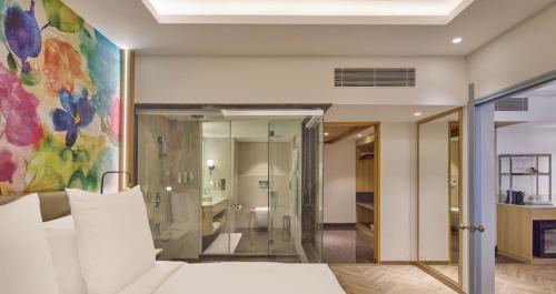 a bedroom with a bed and a painting on the wall at Hotel Royal Orchid Bangalore in Bangalore