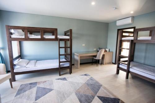 a room with three bunk beds and a desk at Arman Dala Resort in Qaskeleng