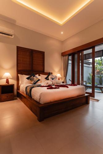 a bedroom with a large bed with a wooden headboard at Villa Mesari Bona in Blahbatu