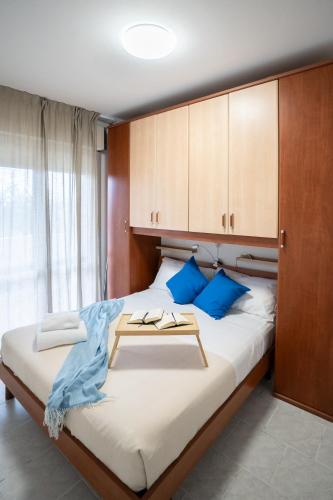 a bedroom with a large bed with blue pillows at Dimora del Mare in Isola Bacucco