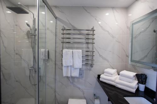 a bathroom with a shower and a sink and towels at Arman Dala Resort in Qaskeleng