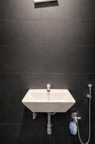 a white sink in a bathroom with a shower at Mutram Heritage Stay in Kanchipuram