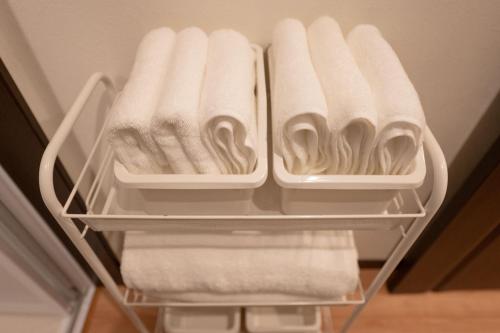 an open refrigerator with white towels and towels at 四季歓居-新裝三層一戶建電車直達關西機場難波心斎橋天王寺住吉大社徒歩圏3ldk貸切 in Osaka
