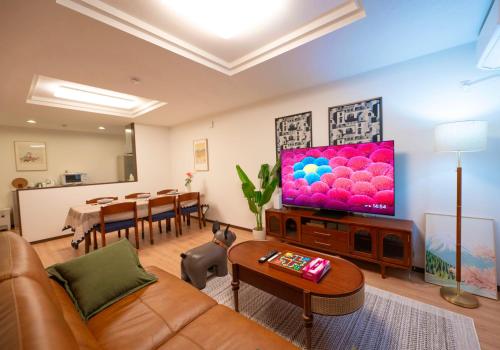 a living room with a couch and a flat screen tv at 四季歓居-新裝三層一戶建電車直達關西機場難波心斎橋天王寺住吉大社徒歩圏3ldk貸切 in Osaka