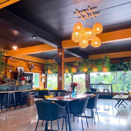 a restaurant with tables and chairs in a room at Nangnon Hill Hug Hotel in Ban Pa Muat