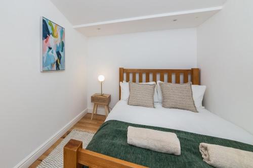 a bedroom with a large bed with a green blanket at Oxford, St Clements, 2-Bed, Minutes to Centre with Private Garden Courtyard in Oxford