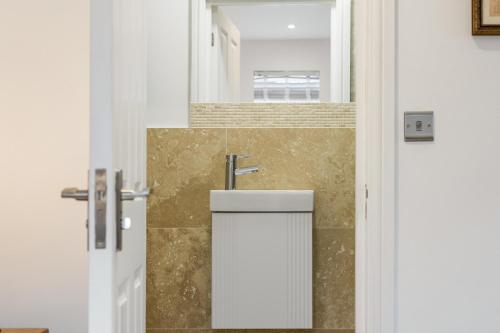 a bathroom with a sink next to a door at Oxford, St Clements, 2-Bed, Minutes to Centre with Private Garden Courtyard in Oxford