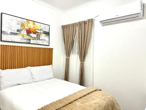 a bedroom with a bed and a air conditioner at Bonno Stay Suite in Gaborone