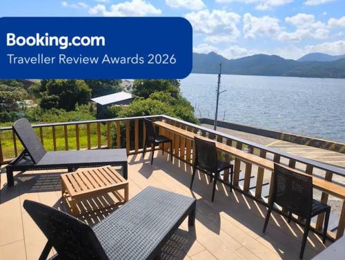 a deck with chairs and tables and a view of the water at INN Kumihama 丹後 一棟貸し 海の宿 INN久美浜 in Kyotango