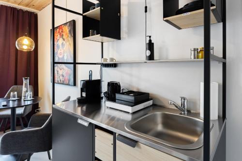 a kitchen with a sink and a table at RS Boardinghouse Aparthotel mit Charme und Hotelservice in St. Gallen