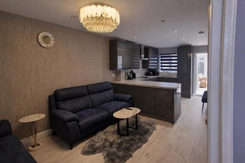 a living room with a couch and a kitchen at Liverpool House Near City Centre in Liverpool