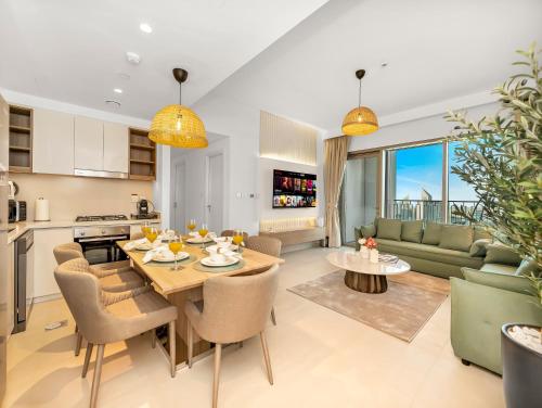 a kitchen and living room with a table and chairs at Royal Vista - Luxury 4BR Apartment at Downtown Views II - Downtown in Dubai