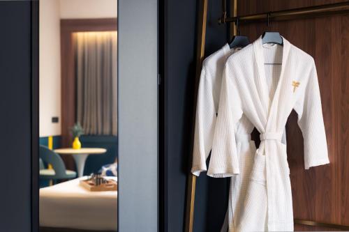 a white robe hanging on a door in a hotel room at Furama City Centre in Singapore