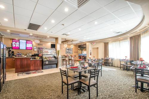 a restaurant with tables and chairs and a bar at Clarion Inn Elmhurst - Oak Brook near I-88, I-290, I-294 in Elmhurst