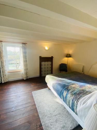 a bedroom with a large bed and a window at Gîte La Vie Verte - Gîte charmant 3 etoiles classé Meublé de Tourisme in Saint-Domet