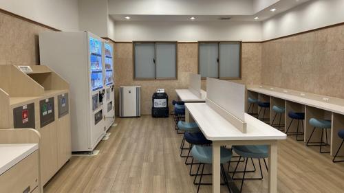 a cafeteria with counters and stools in a room at Toyoko Inn Osaka Umeda Higashi in Osaka