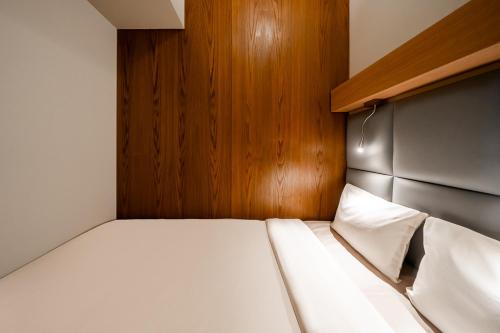 a small bedroom with a bed with a wooden headboard at Sleepover Terminal 3, Concourse C - formerly sleep 'n fly in Dubai