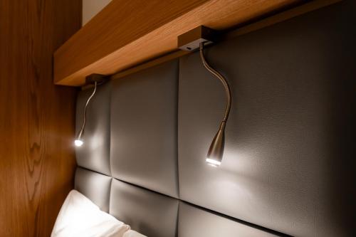 a bedroom with two lights hanging on the wall at Sleepover Terminal 3, Concourse C - formerly sleep 'n fly in Dubai