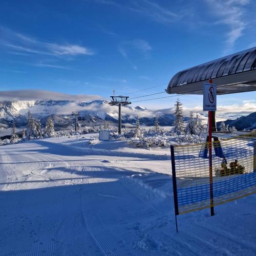 a snow covered ski slope with a ski lift at Baby- und Kinderbauernhof Montaning in Forstau