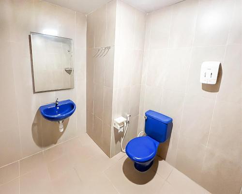 a bathroom with a blue toilet and a sink at Hotel Beverly Inn Batam Center in Batam Center