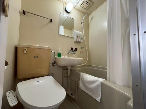 a small bathroom with a toilet and a sink at N's Hotel 平和公園 in Hiroshima