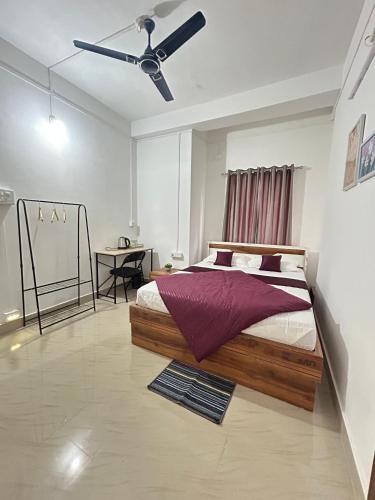 a bedroom with a bed and a ceiling fan at Shivalik stays in Jorhat