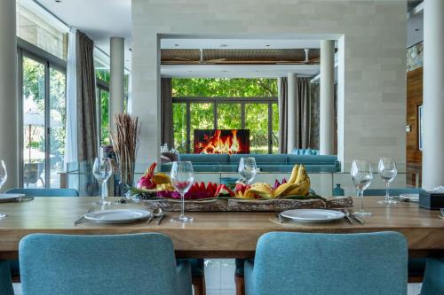a dining room with a table and a fireplace at Villa Skyfall Thailand Phuket in Panwa Beach