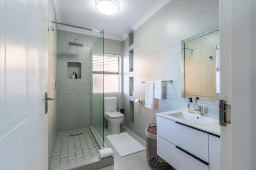 a bathroom with a toilet and a sink and a shower at Rosebud 4 Beacon Point in Mossel Bay