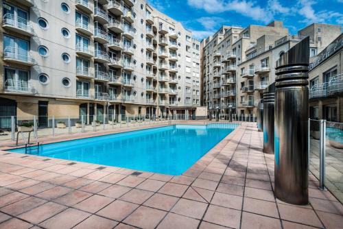 a swimming pool in front of some apartment buildings at Studio Zeezicht in Ostend