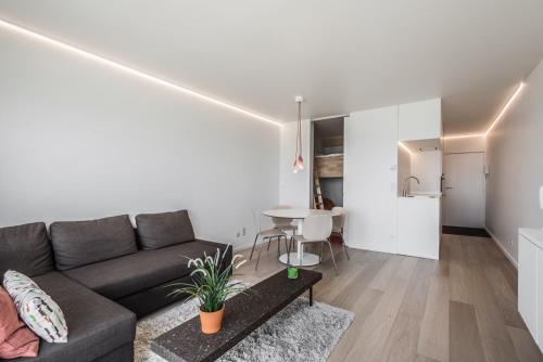 a living room with a couch and a table at Studio Zeezicht in Ostend