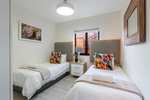 a bedroom with two beds and a window at Rosebud 4 Beacon Point in Mossel Bay